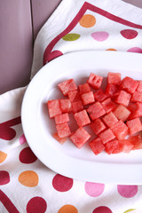 Slices of watermelon on polka dot napkin on wooden background