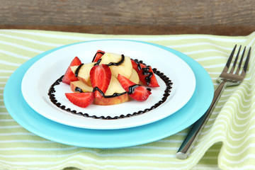 fresh tasty fruit salad on table, on wooden background