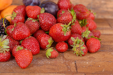 Ripe fruits and berries on wooden background