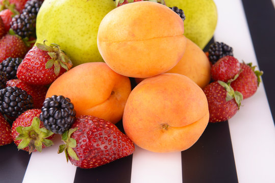 Ripe fruits and berries on striped background