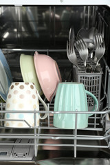 Fototapeta na wymiar Open dishwasher with clean utensils in it