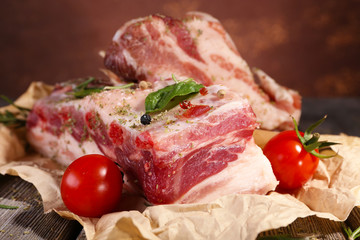 raw bacon with spices and tomatoes on wooden table
