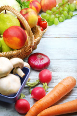 Fresh organic vegetables and fruits on wooden background