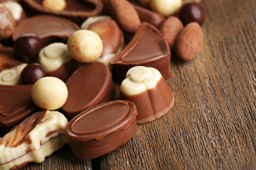 Different kinds of chocolates on wooden table close-up