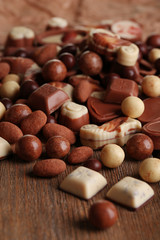 Different kinds of chocolates on wooden table close-up