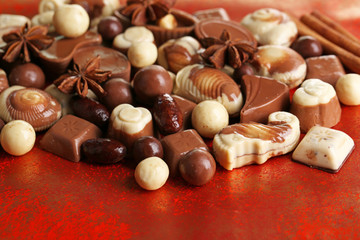 Different kinds of chocolates on red background