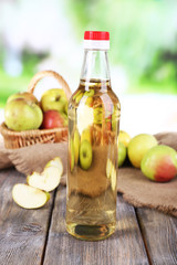Apple cider vinegar in glass bottle and ripe fresh apples,
