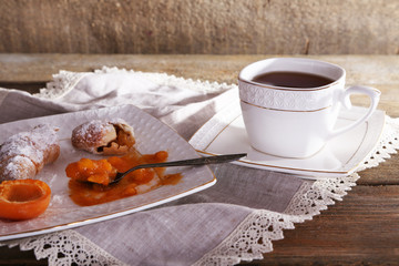 still life with cup of tea and apricot jam on wooden table