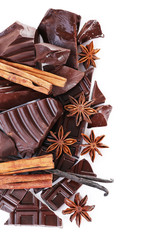 Cracked chocolate bar with spices on white background