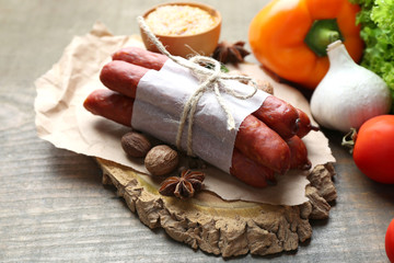 Composition of smoked thin sausages, mustard in bowl and spices