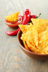 Tasty nachos, red tomatoes and chili pepper in color bowl