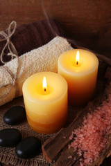 Spa stones with candles and sea salt on wooden background
