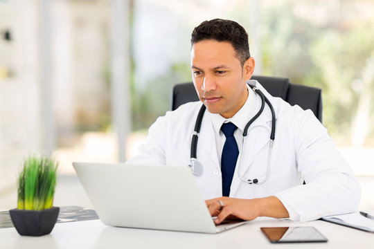 Mid Age Medical Doctor Using Laptop
