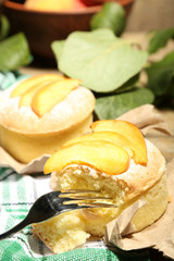 Tasty mini cakes with fresh peach, on table