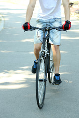 Naklejka premium Young man riding bicycle on paved path, active lifestyle and outdoor recreation, healthy transportation and urban cycling