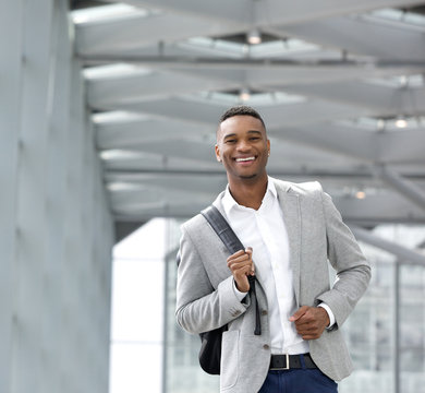 Cheerful Young Man Walking At Airport With Bag