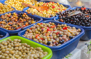 Pickled olives in plastic box on shop counter