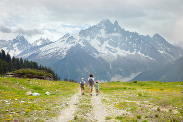 Fototapeta na wymiar Father and two boys hike on the mountain trail
