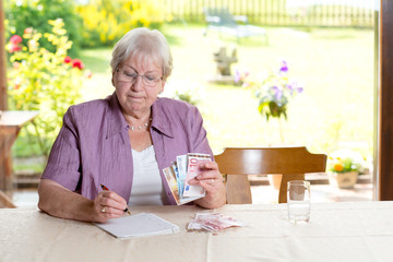 female senior is calculating her budget