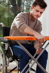 Man on wheelchair preparing iron board