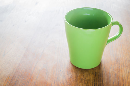 Green ceramic cup on wooden table