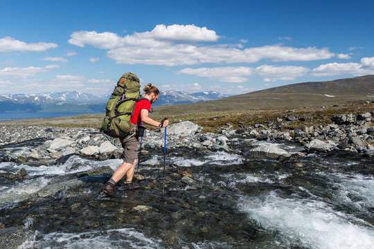 Hiker Is Crossing The River