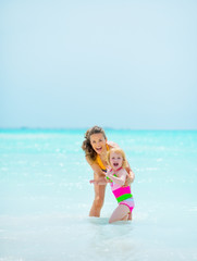 Naklejka premium Portrait of mother and baby girl at seaside
