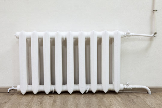 White steel radiator of central heating in room