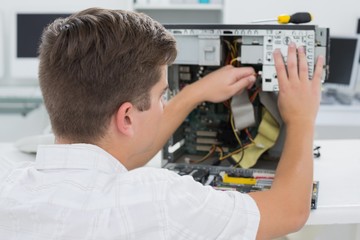 Young technician working on broken computer