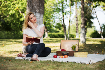 Young fashion woman reading a book in a city park