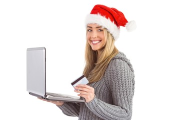 Naklejka premium Festive blonde shopping online with laptop