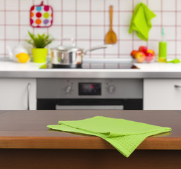 Wooden table with napkin on kitchen background