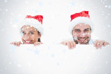 Composite image of festive young couple smiling at camera