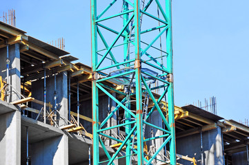 Crane and building construction site against blue sky