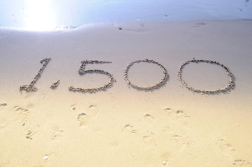 Numbers left written on wet sand.