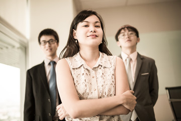 Happy business team with arms crossed at the office
