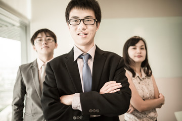 Happy business team with arms crossed at the office