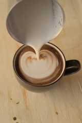 Obraz na płótnie Canvas Coffee latte art on the wood vintage desk