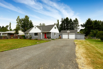 Fototapeta premium Grey house with white trim and red door