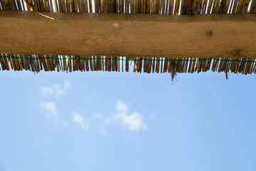 horizontal traditional reed and wooden roof with blue sky