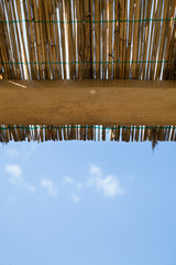 Vertical traditional reed and wooden roof with blue sky