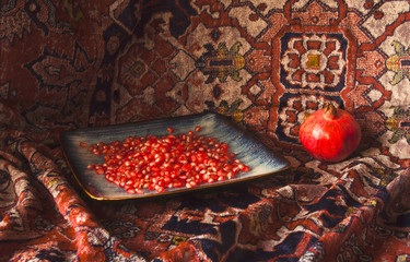 Still life of pomegranate and carpet