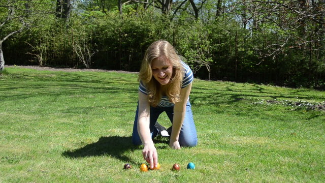girl have fun playing Easter game with painted colorful eggs