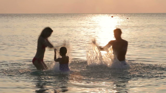 Silhouette Of Family Having Fun In Sea 