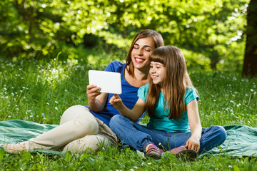 Mother and daughter using digital tablet