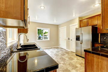 Kitchen with black granite tops and wooden cabinets