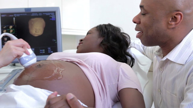 Pregnant Woman Having 4D Ultrasound Scan With Partner