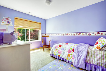 Bright cheerful bedroom in purple color with colorful bedding