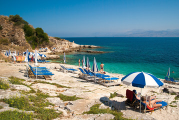 Fototapeta na wymiar Kassiopi Beach, Corfu Island, Greece. Sunbeds and umbrellas