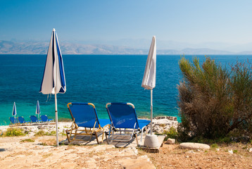 Sunbeds and umbrellas on the beach in Corfu Island, Greece